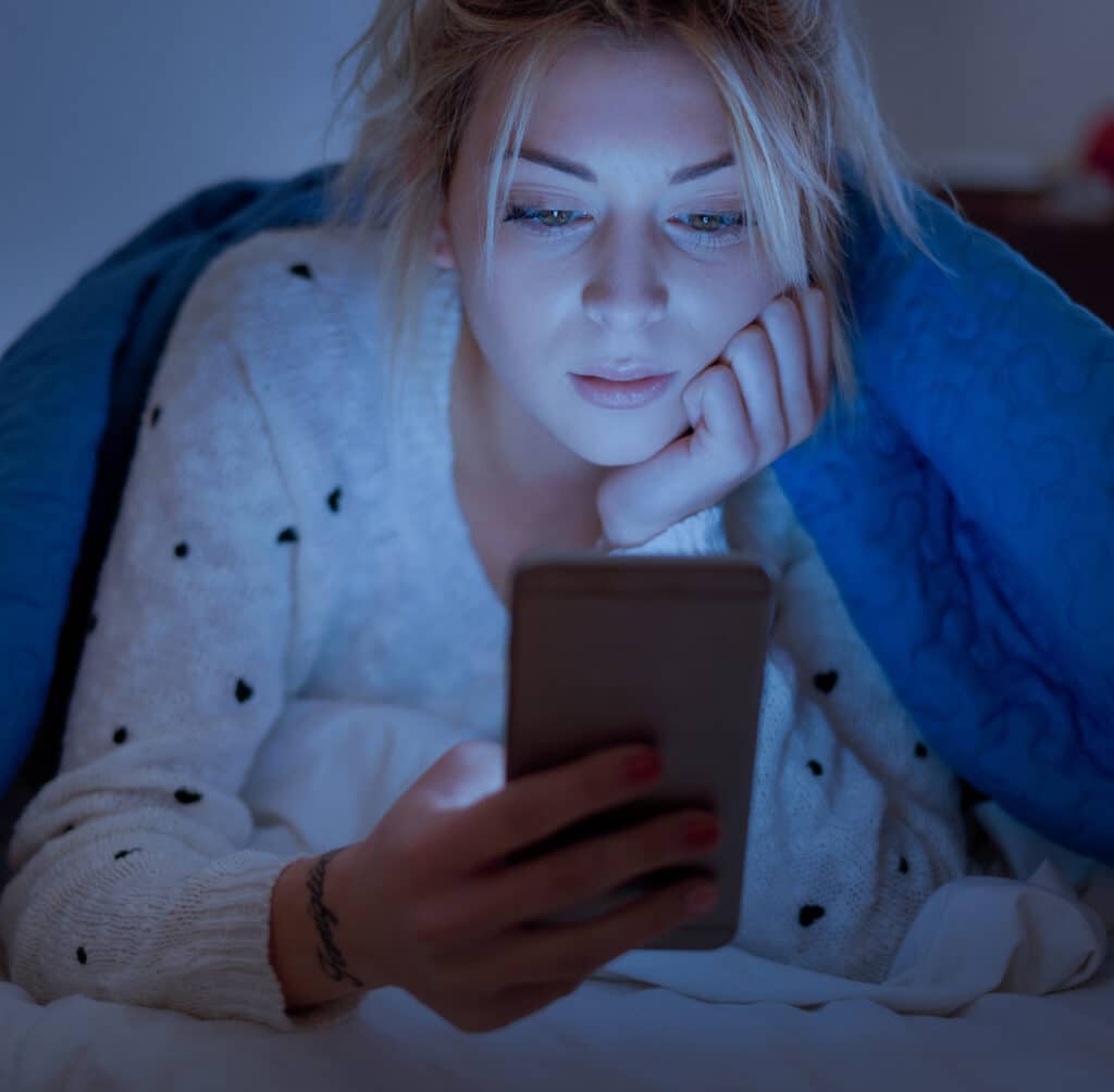 Vrouw met smartphone en blauw licht